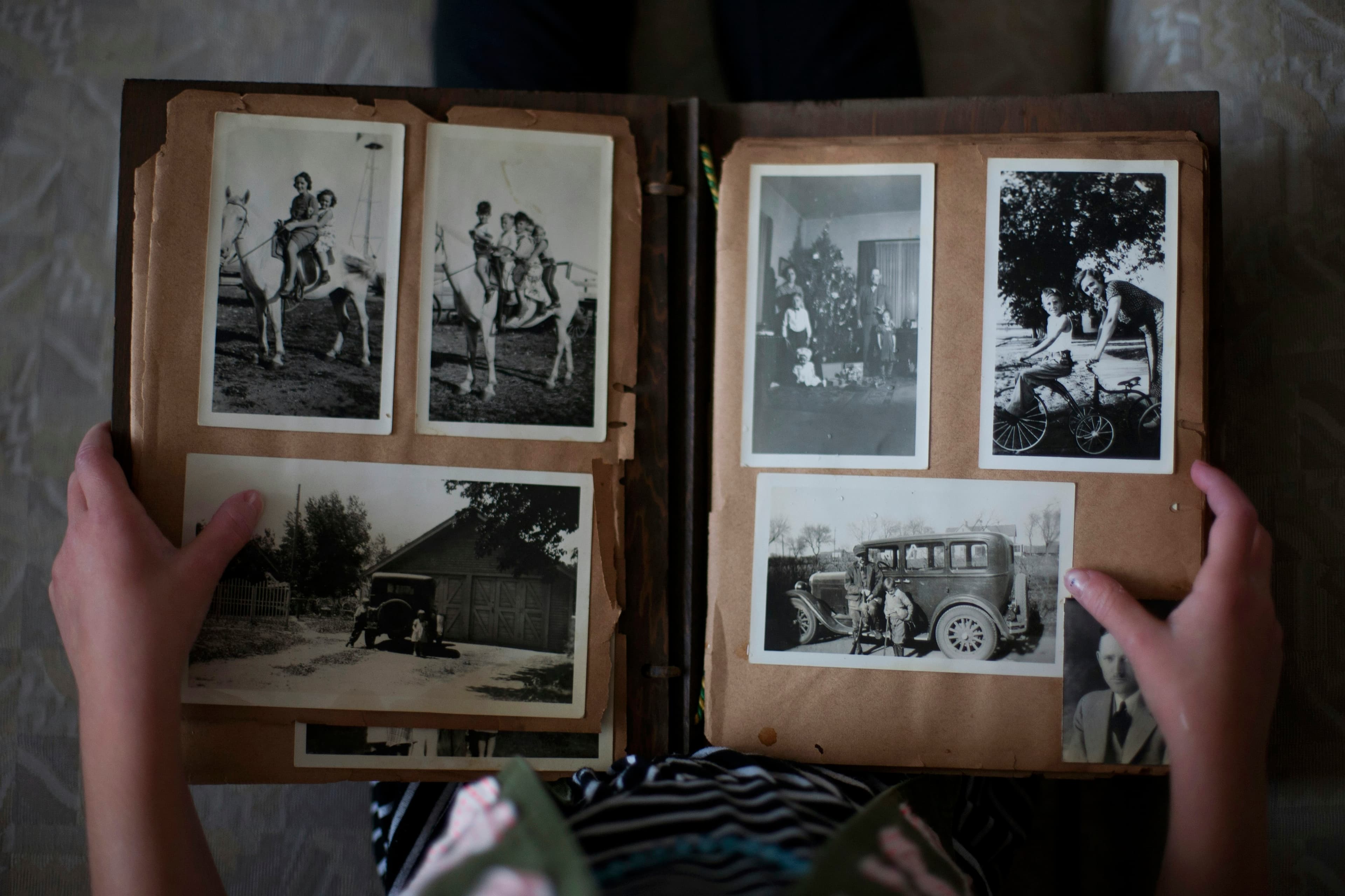 Person opening a photo album of old family photos