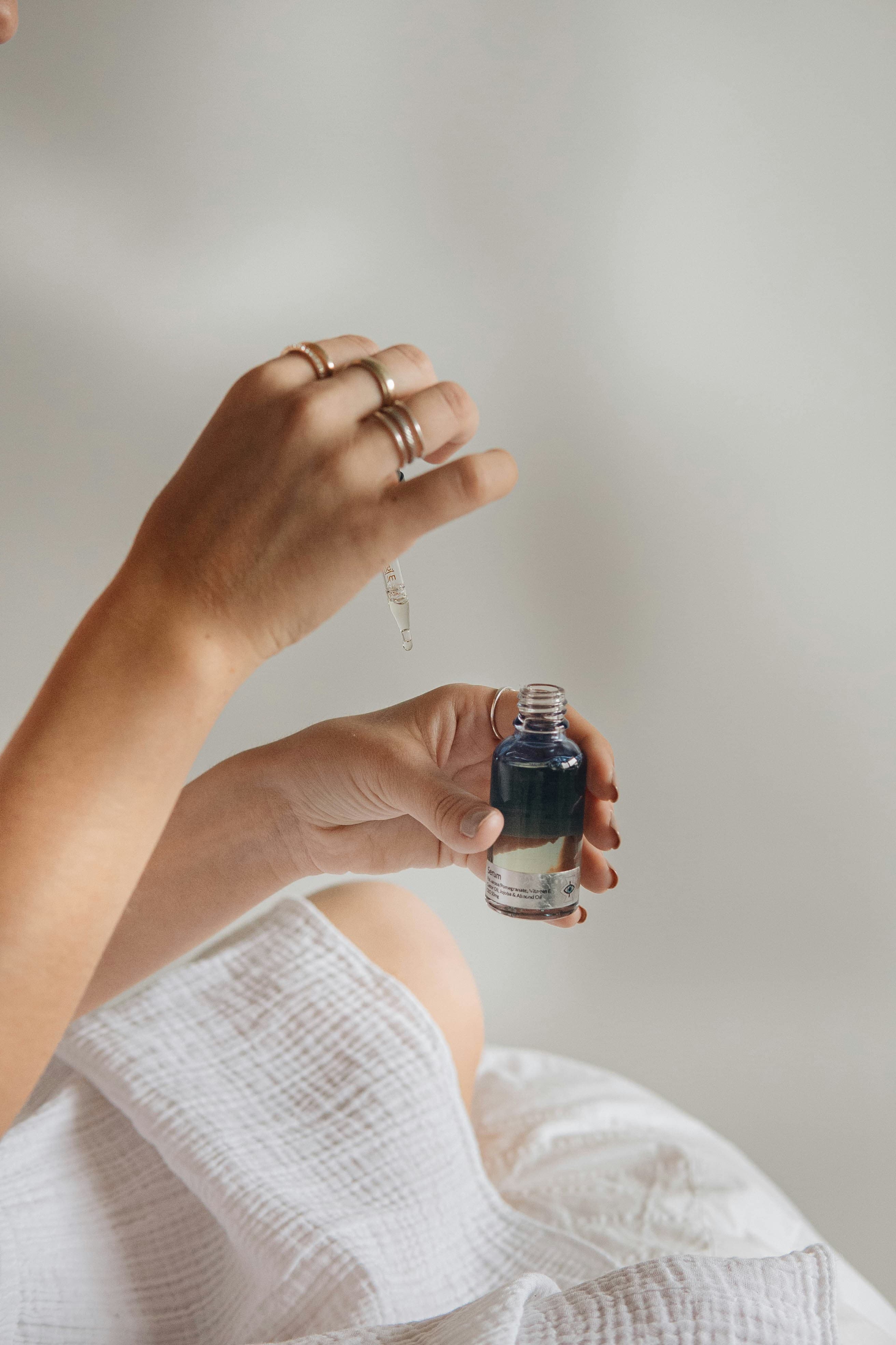 Hand holding a dark serum bottle